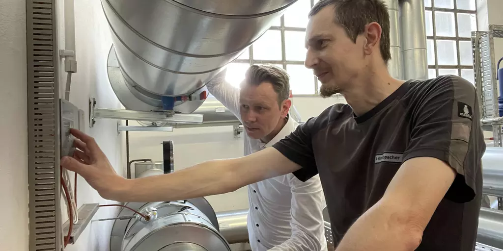 Two employees of the Schwabe Group at a heat meter.