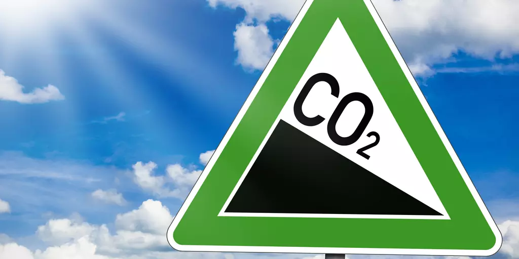 Straßenschild mit sinkendem CO2-Ausstoß