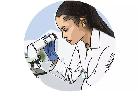 A female laboratory worker is looking through a microscope