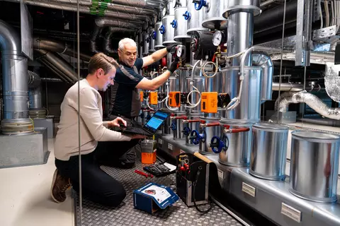 Zwei Schwabe-Mitarbeiter bei einer Instandhaltungsmaßnahme am Heizungsverteiler