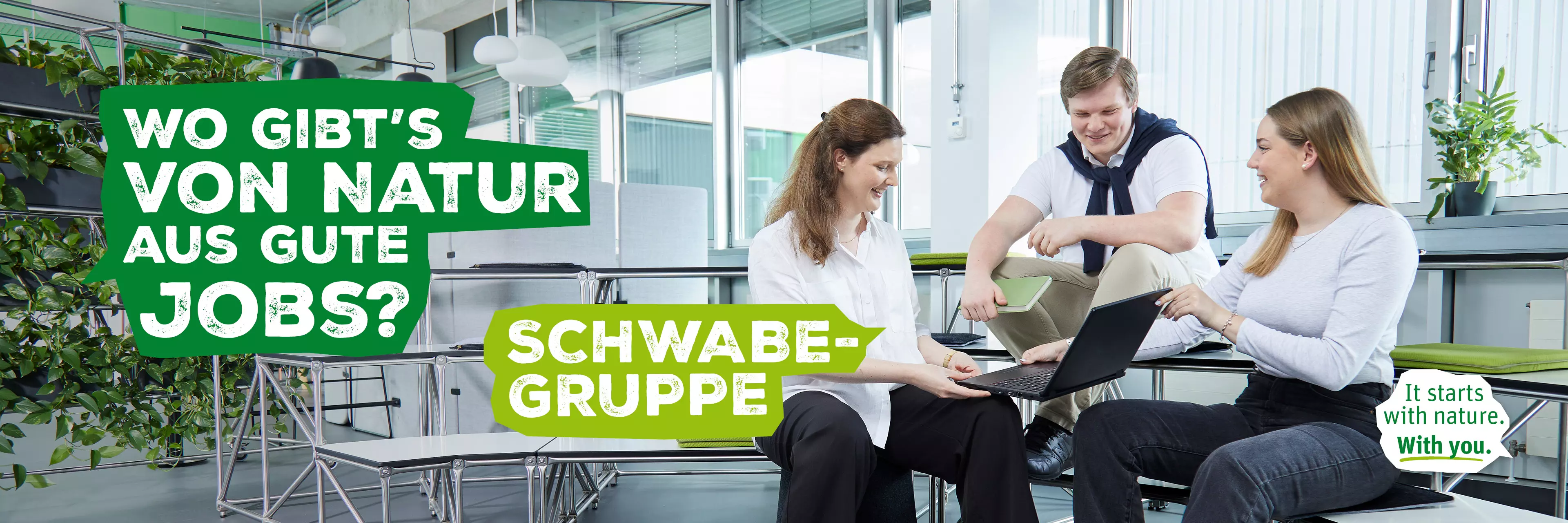 Drei Personen im Austausch in einem Atrium